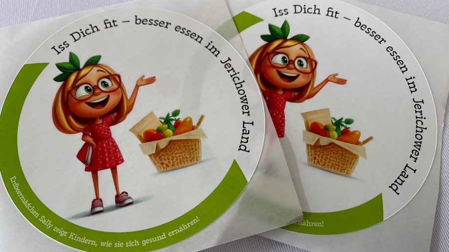 2 runde Sticker mit einer comichaften Mädchenfigur und einem Obstkorb